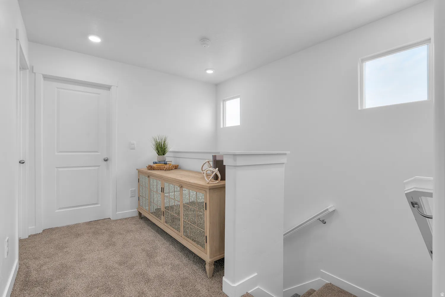 Corridor featuring an upstairs landing, light carpet, and recessed lighting