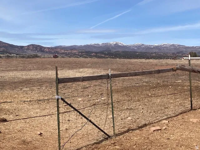View of yard with a mountain view, a view of countryside, and a gate