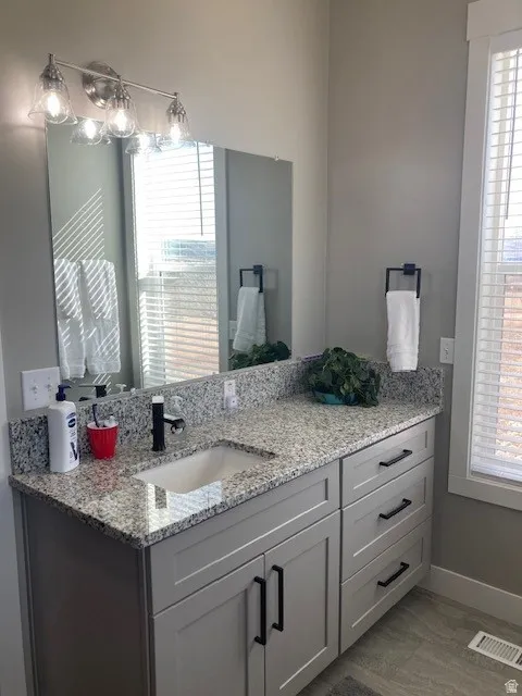 Bathroom featuring vanity and healthy amount of natural light