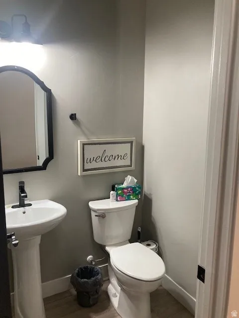 Half bathroom with toilet and baseboards