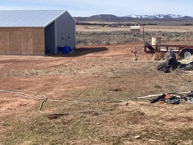 View of yard featuring a mountain view, an outbuilding, and a view of countryside