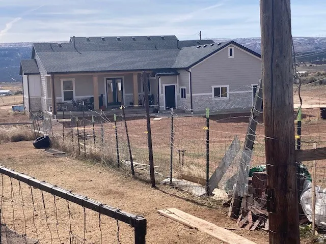 Rear view of property with a patio area, stone siding, and french doors