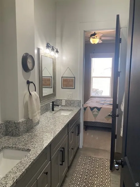 Basement Ensuite bathroom with double vanity and ceiling fan