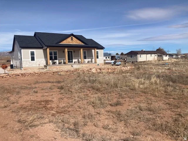 View of front facade featuring covered porch and stone siding also ADU next to main Home