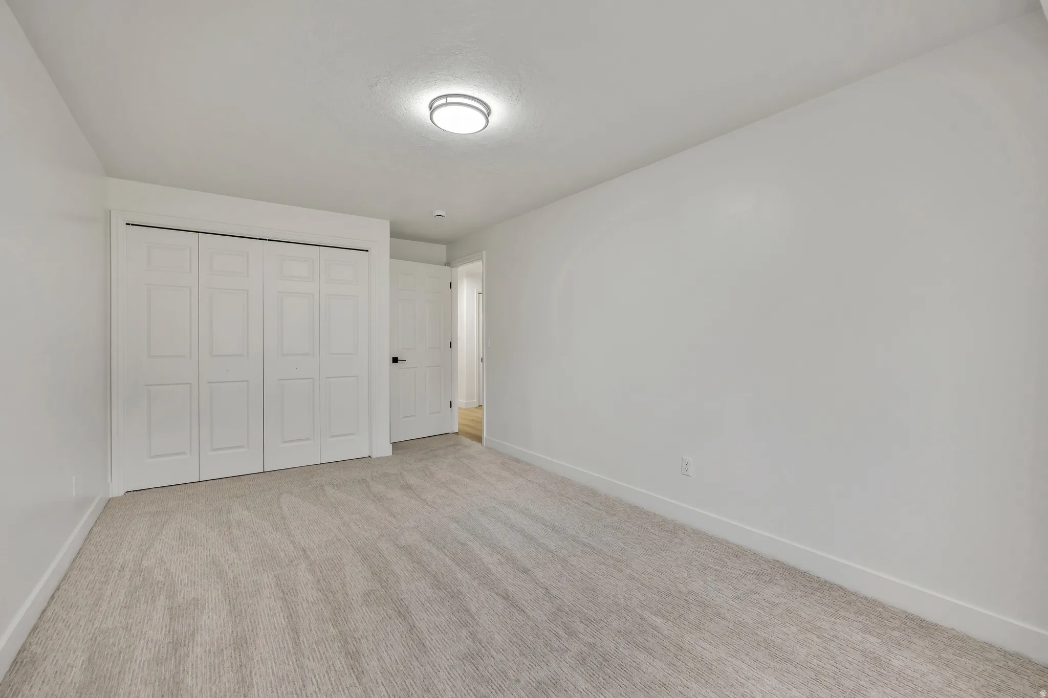 Unfurnished bedroom with a closet and light colored carpet