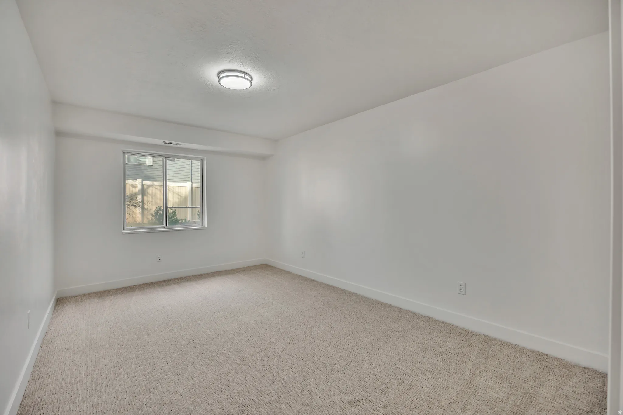 Unfurnished room with baseboards and light carpet