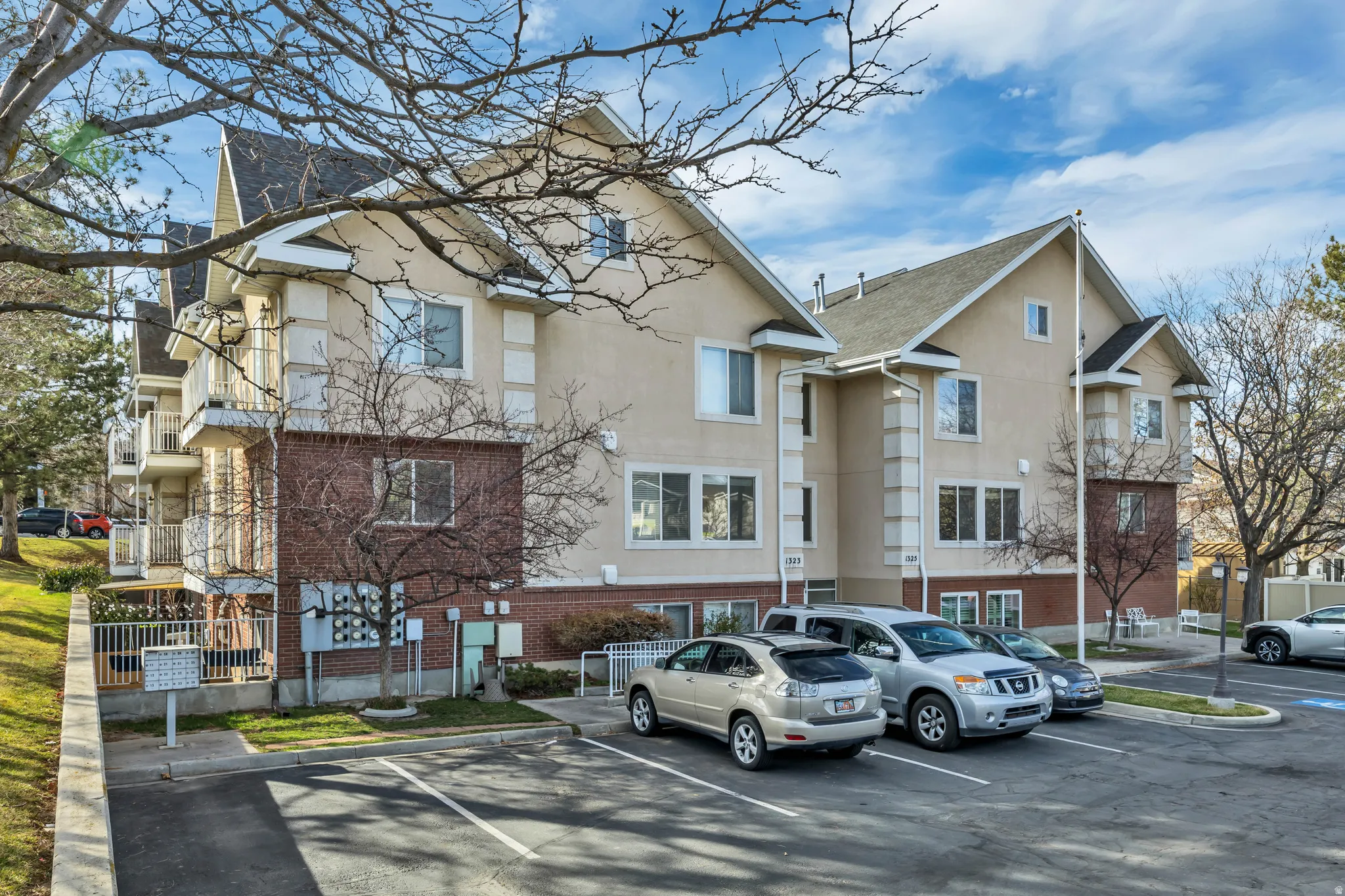 View of apartment building / complex featuring uncovered parking