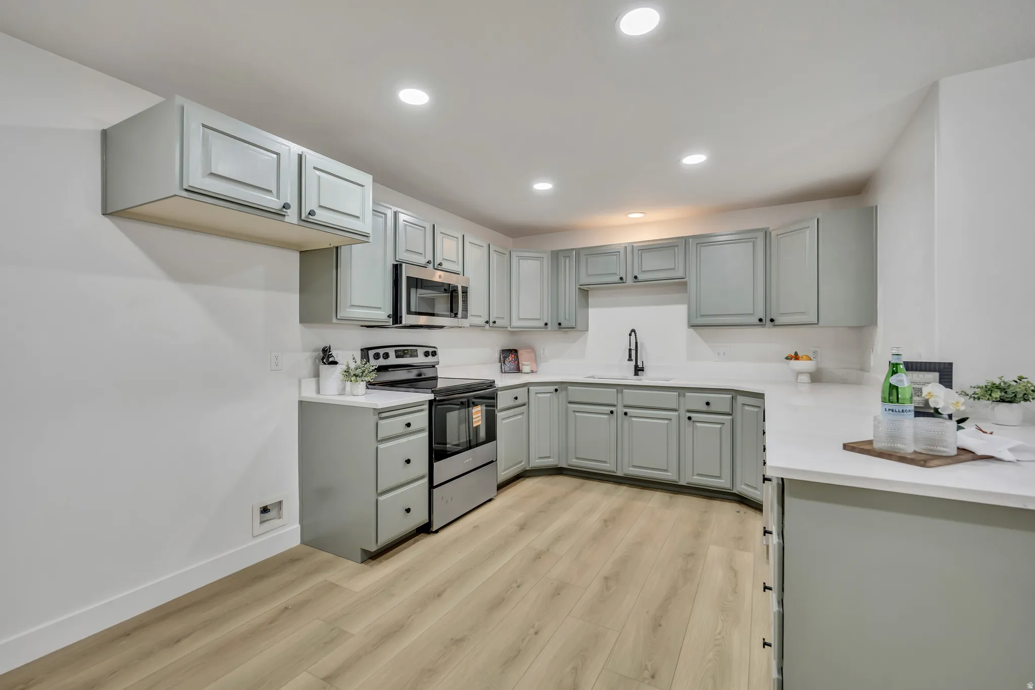 Kitchen featuring stainless steel appliances, light wood-style flooring, recessed lighting, and gray cabinetry