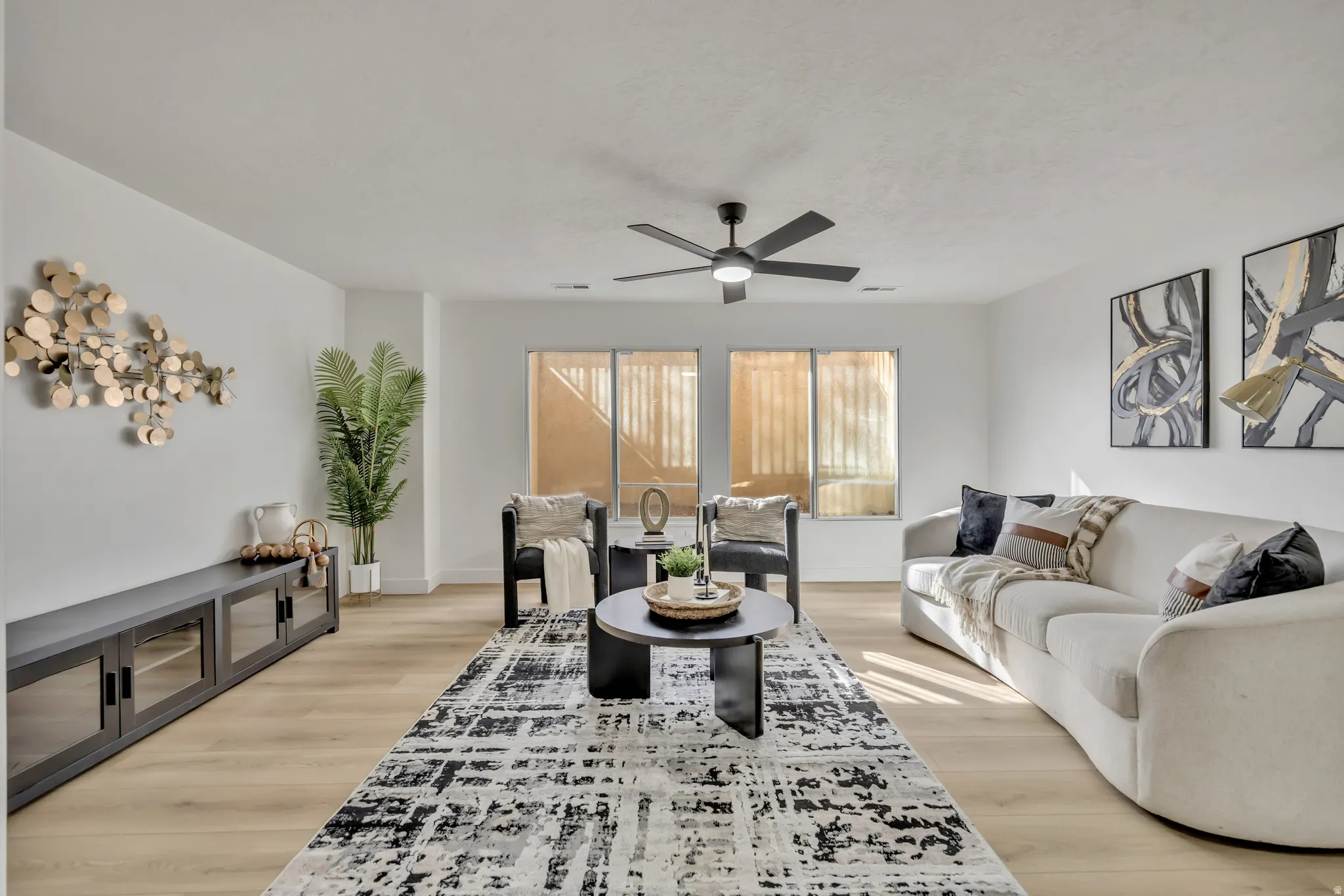 Living room with light wood-type flooring and ceiling fan