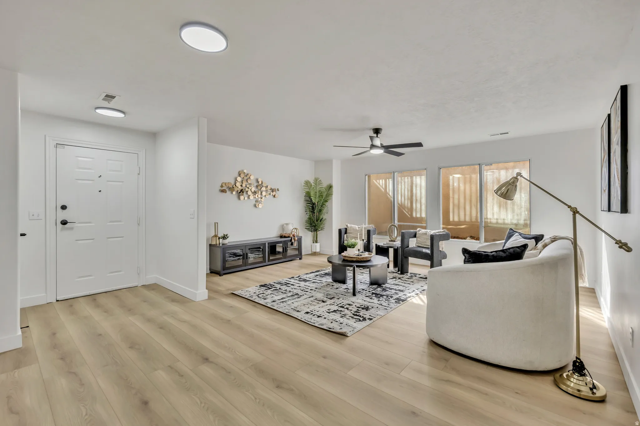 Living room with light wood-style floors and a ceiling fan