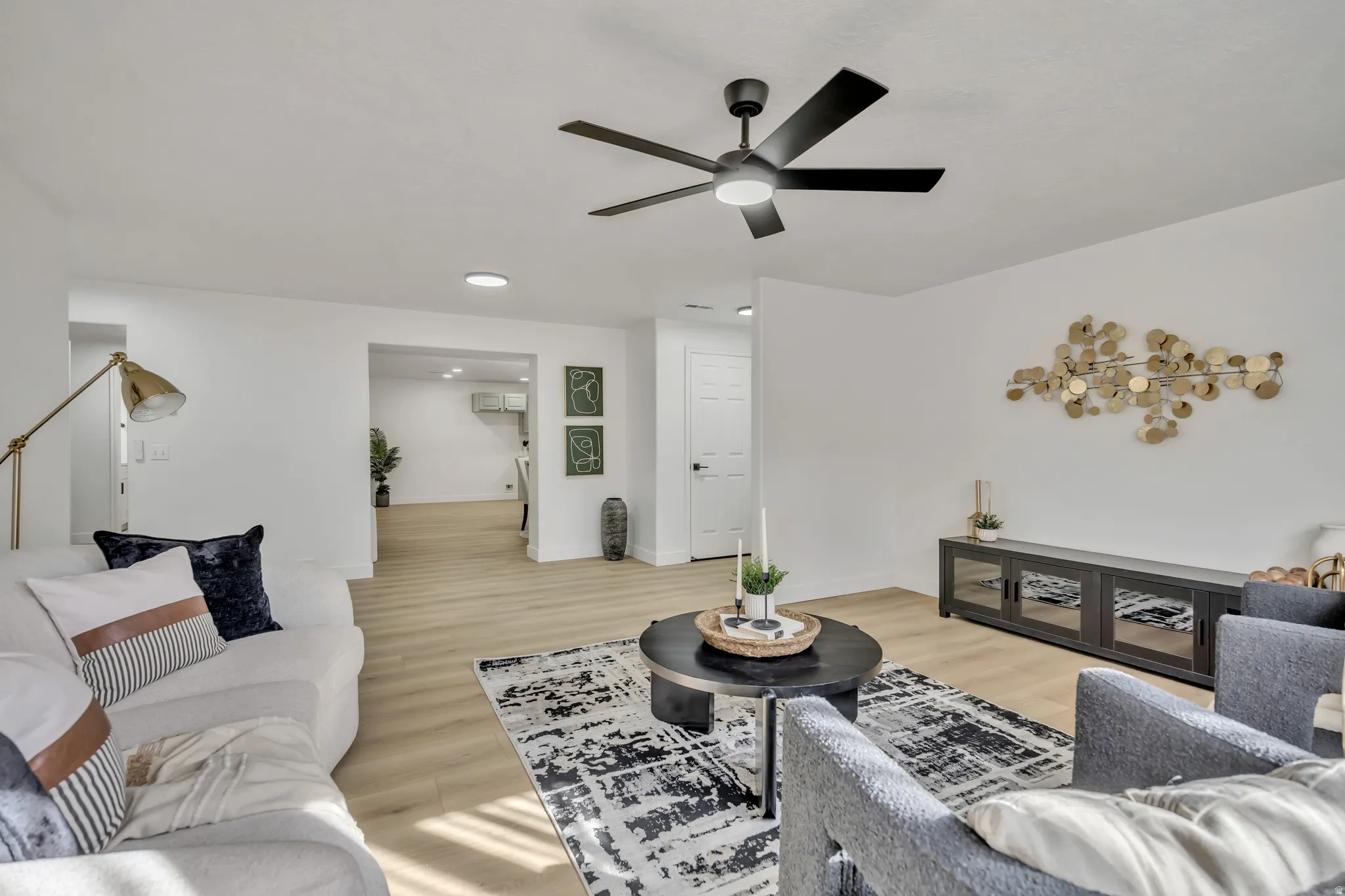 Living area featuring light wood-style floors and a ceiling fan