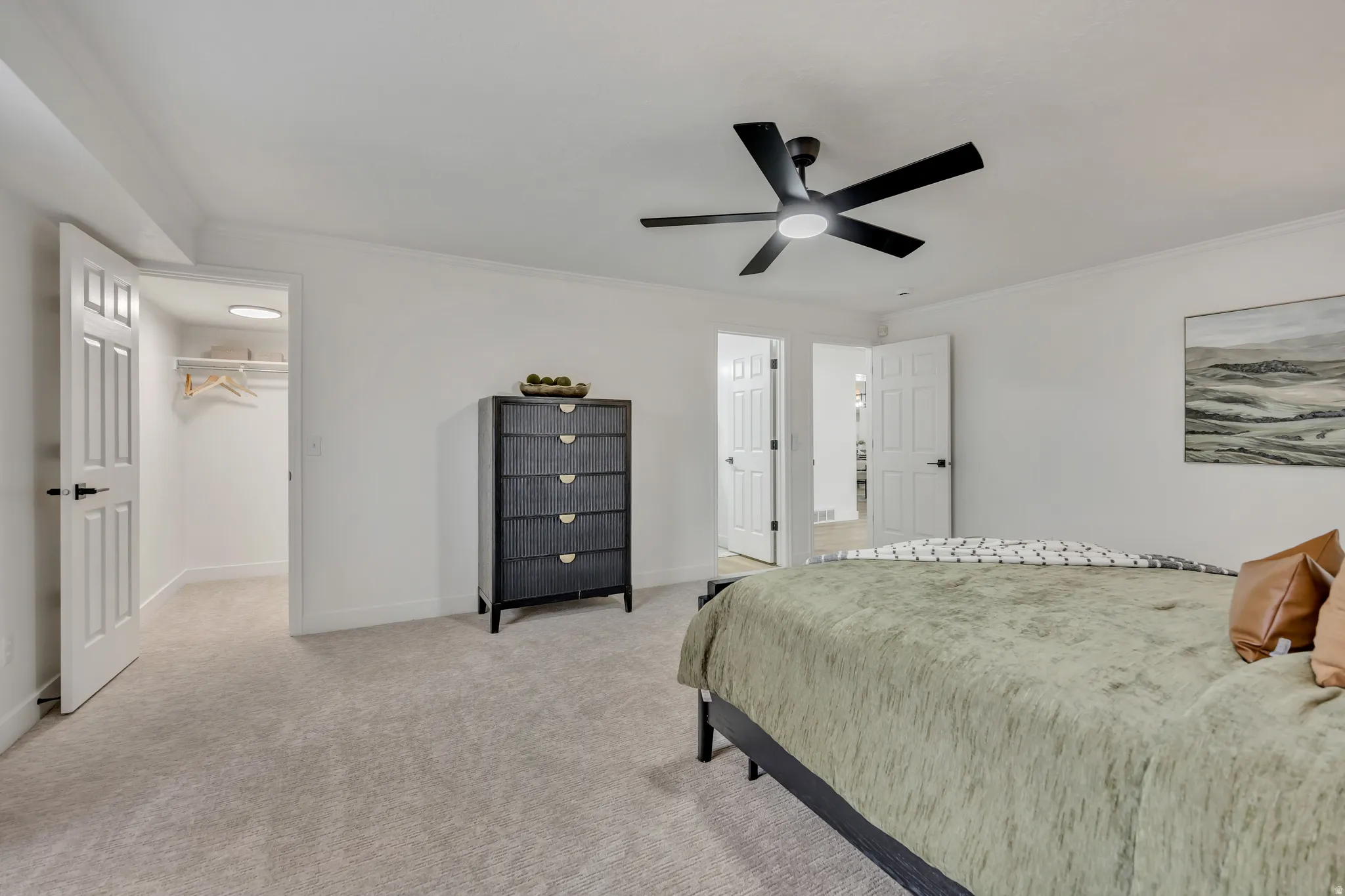 Bedroom featuring light carpet, crown molding, and a ceiling fan