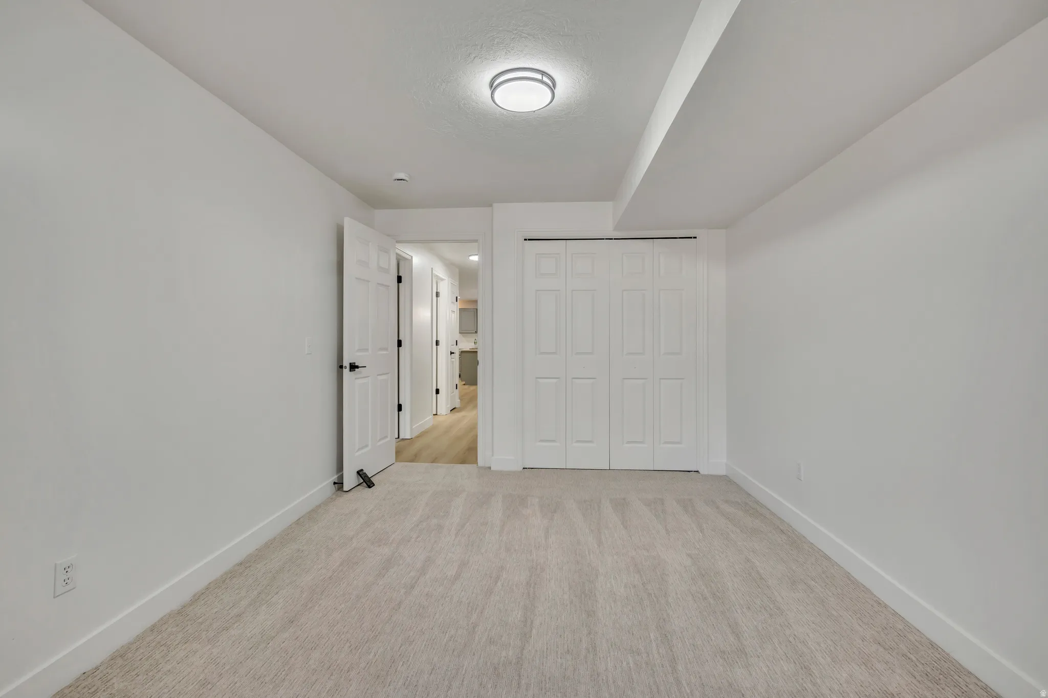 Unfurnished bedroom featuring a closet and light colored carpet