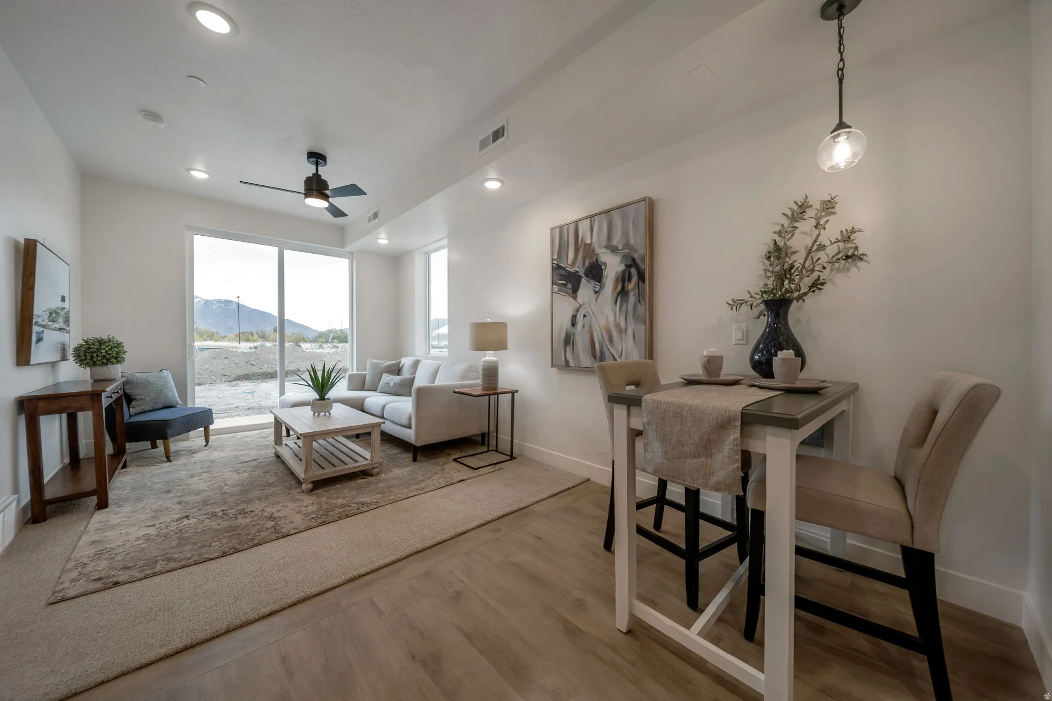 Living area with a mountain view, light wood finished floors, a ceiling fan, and recessed lighting