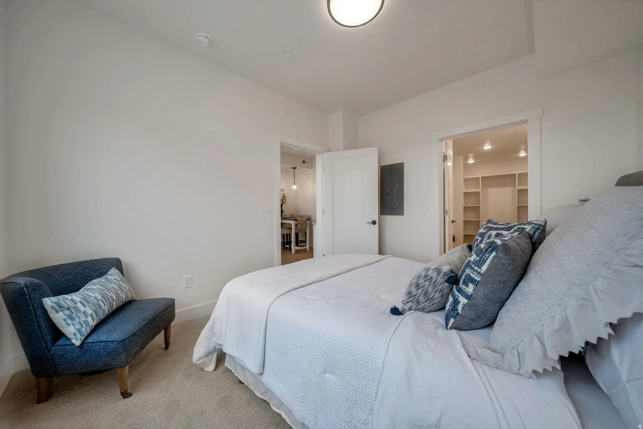 Bedroom with carpet, electric panel, and a spacious closet