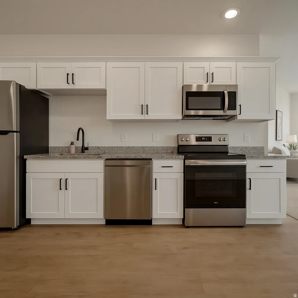 Kitchen with white cabinetry, stainless steel appliances, light stone countertops, light wood finished floors, and recessed lighting