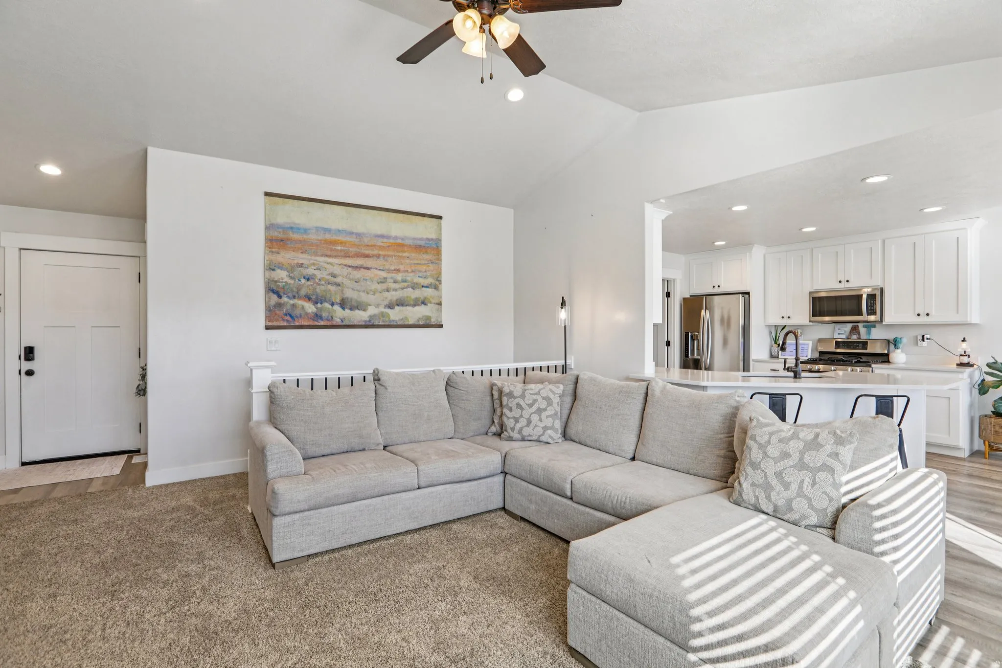 Living area with a ceiling fan, recessed lighting, and lofted ceiling