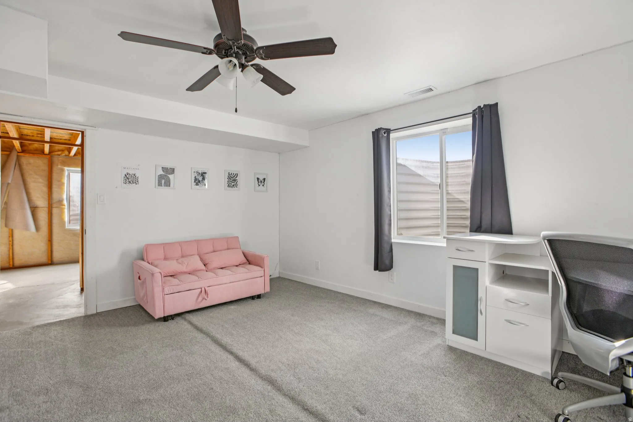 Office with light carpet and a ceiling fan