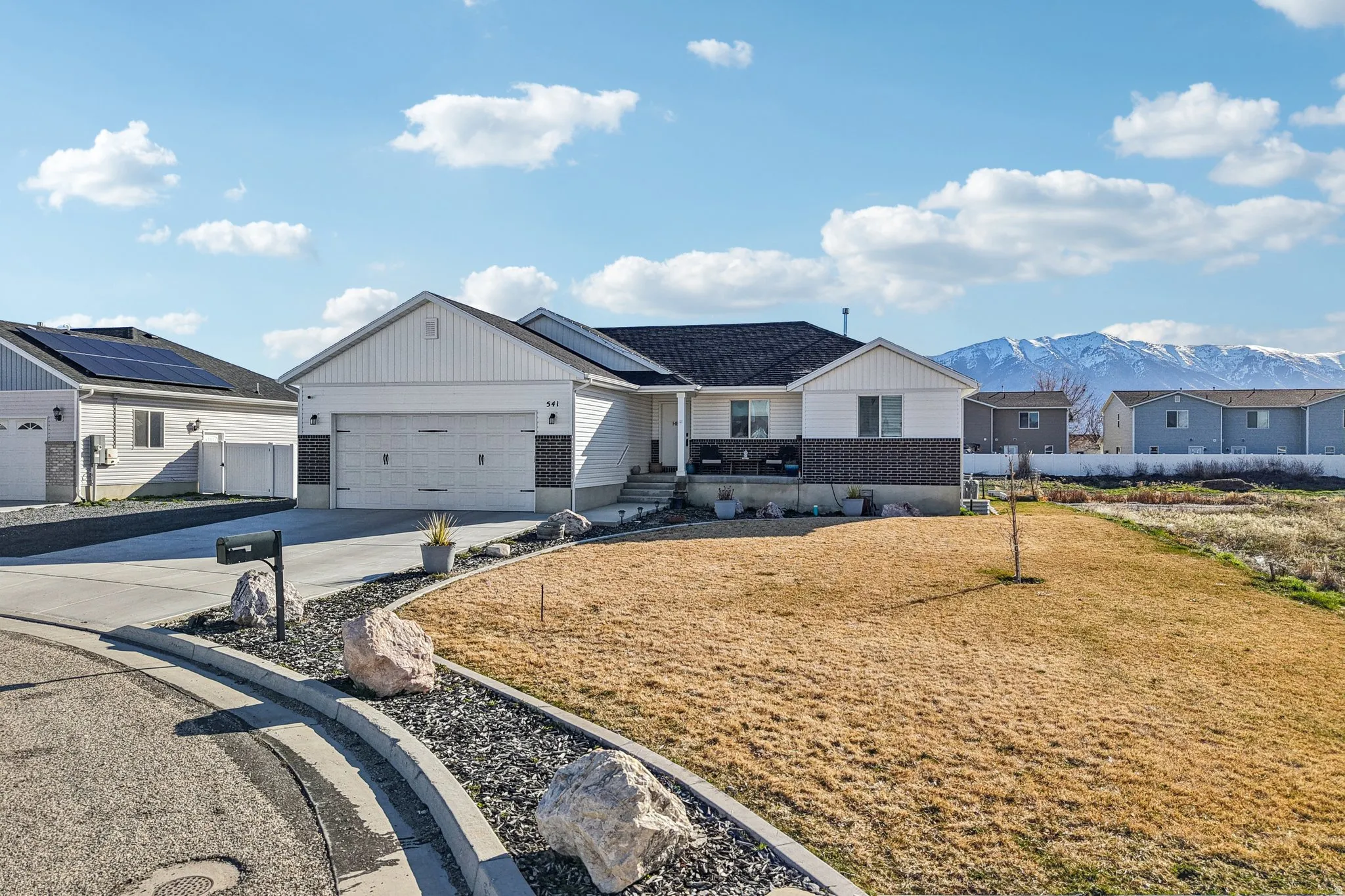 View of front of property with concrete driveway, covered porch, a mountain view, a garage, and a residential view