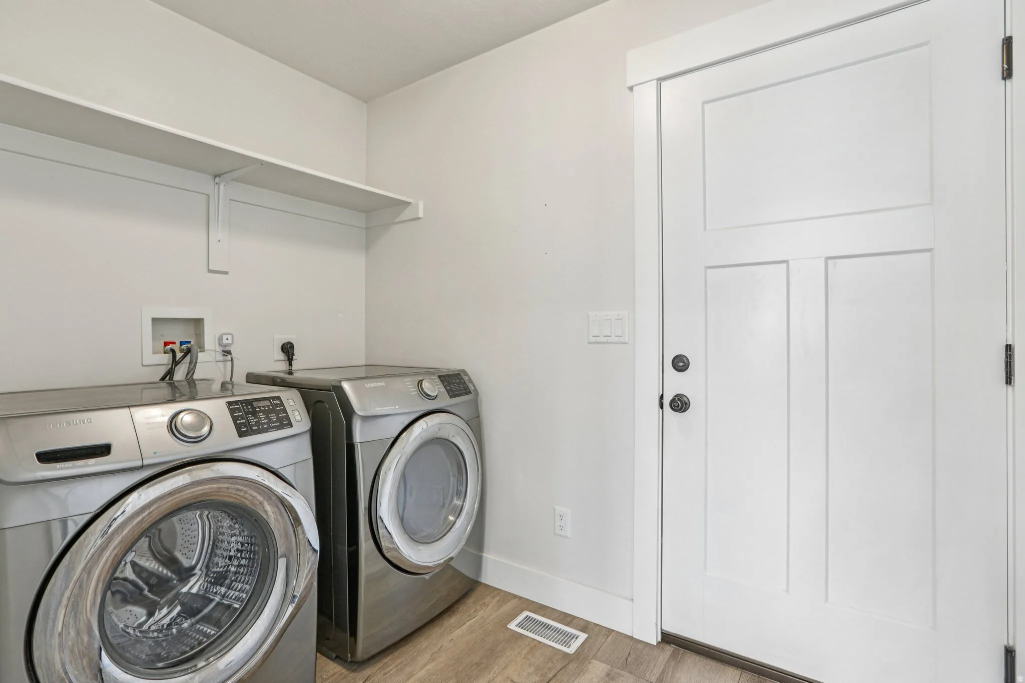 Laundry area featuring light wood-style floors and washing machine and dryer