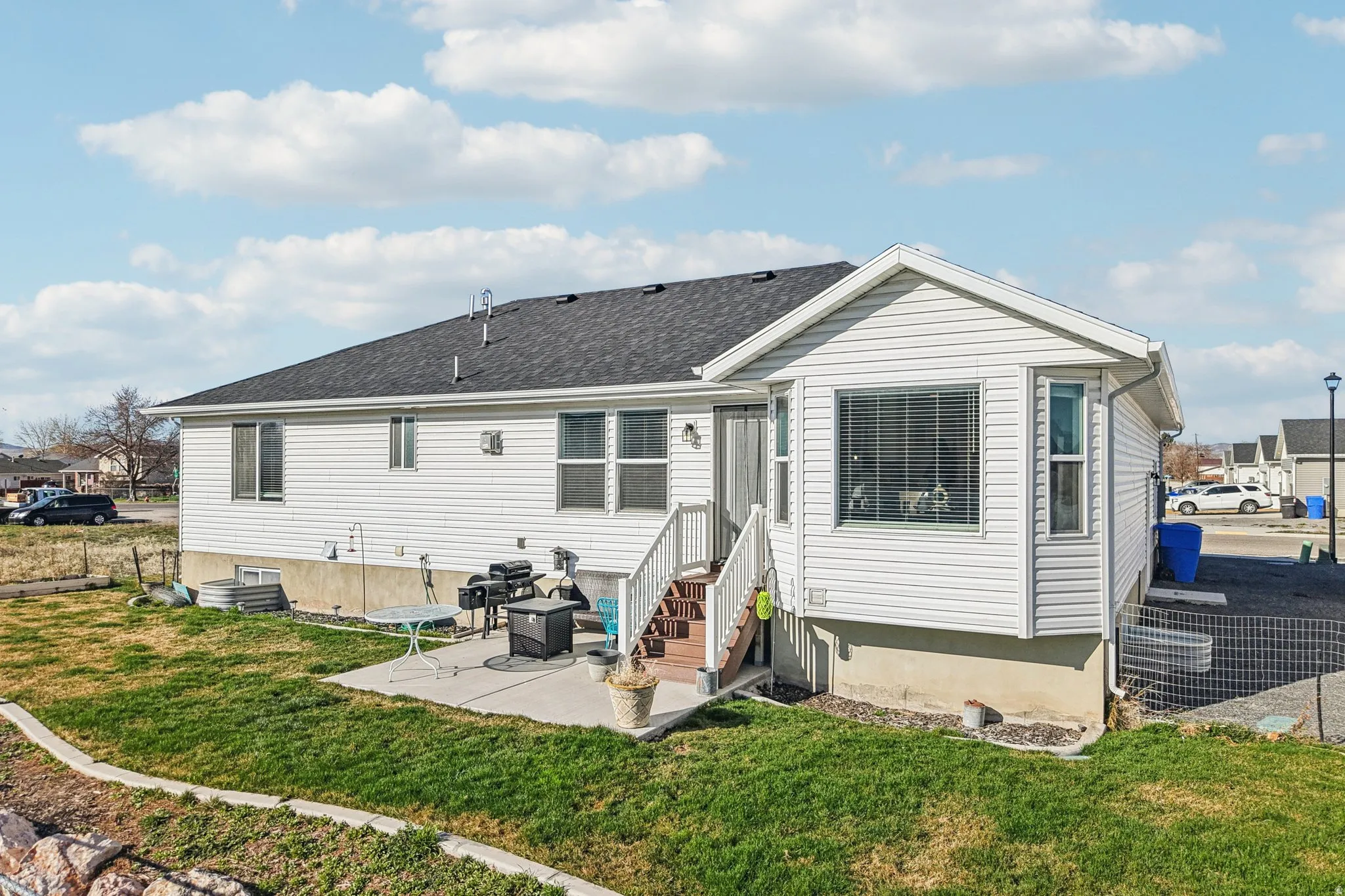 Rear view of property featuring a patio area, entry steps, and roof with shingles