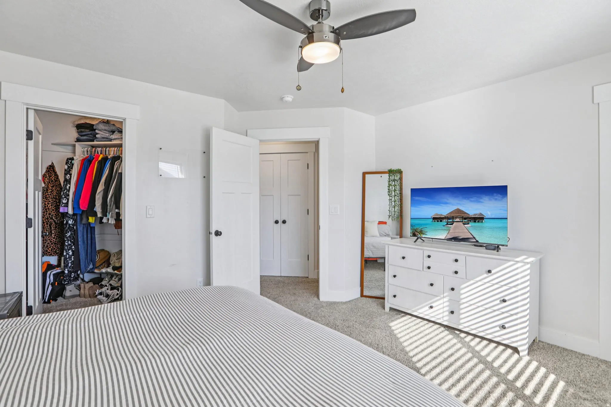 Bedroom featuring light colored carpet and ceiling fan