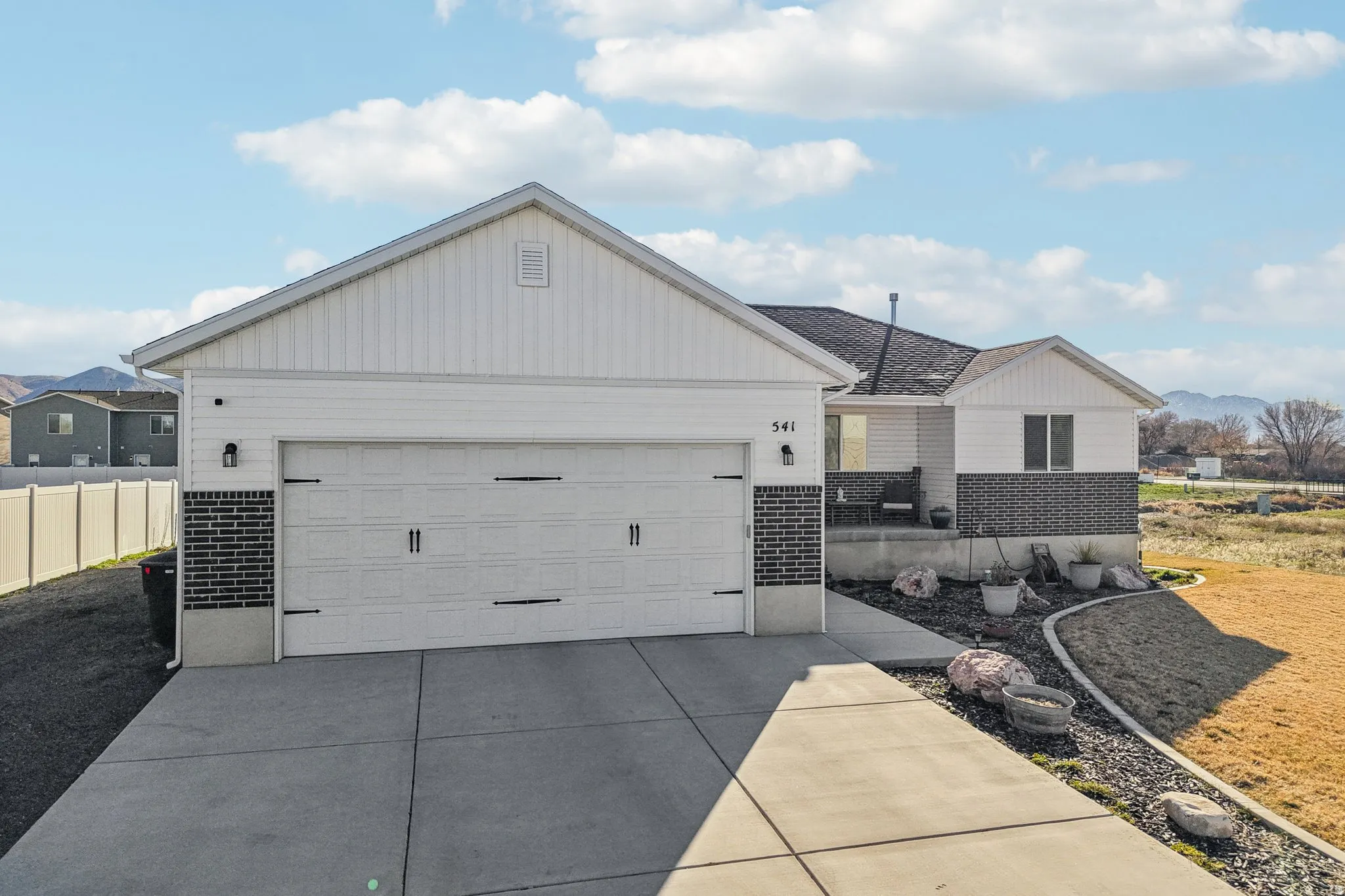 View of front of house with brick siding, a mountain view, concrete driveway, and an attached garage