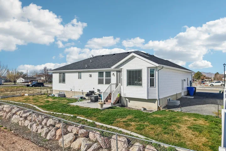Back of house featuring a patio, entry steps, and roof with shingles