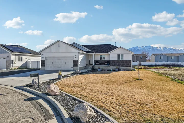 View of front of property with concrete driveway, covered porch, a mountain view, a garage, and a residential view