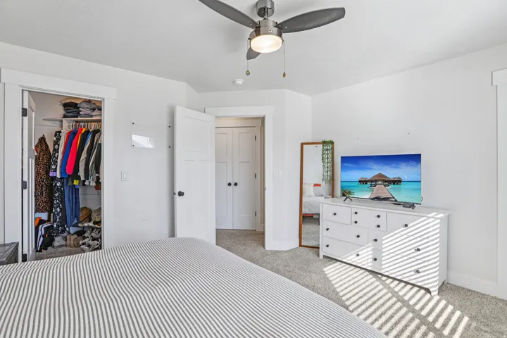 Bedroom featuring light colored carpet and ceiling fan
