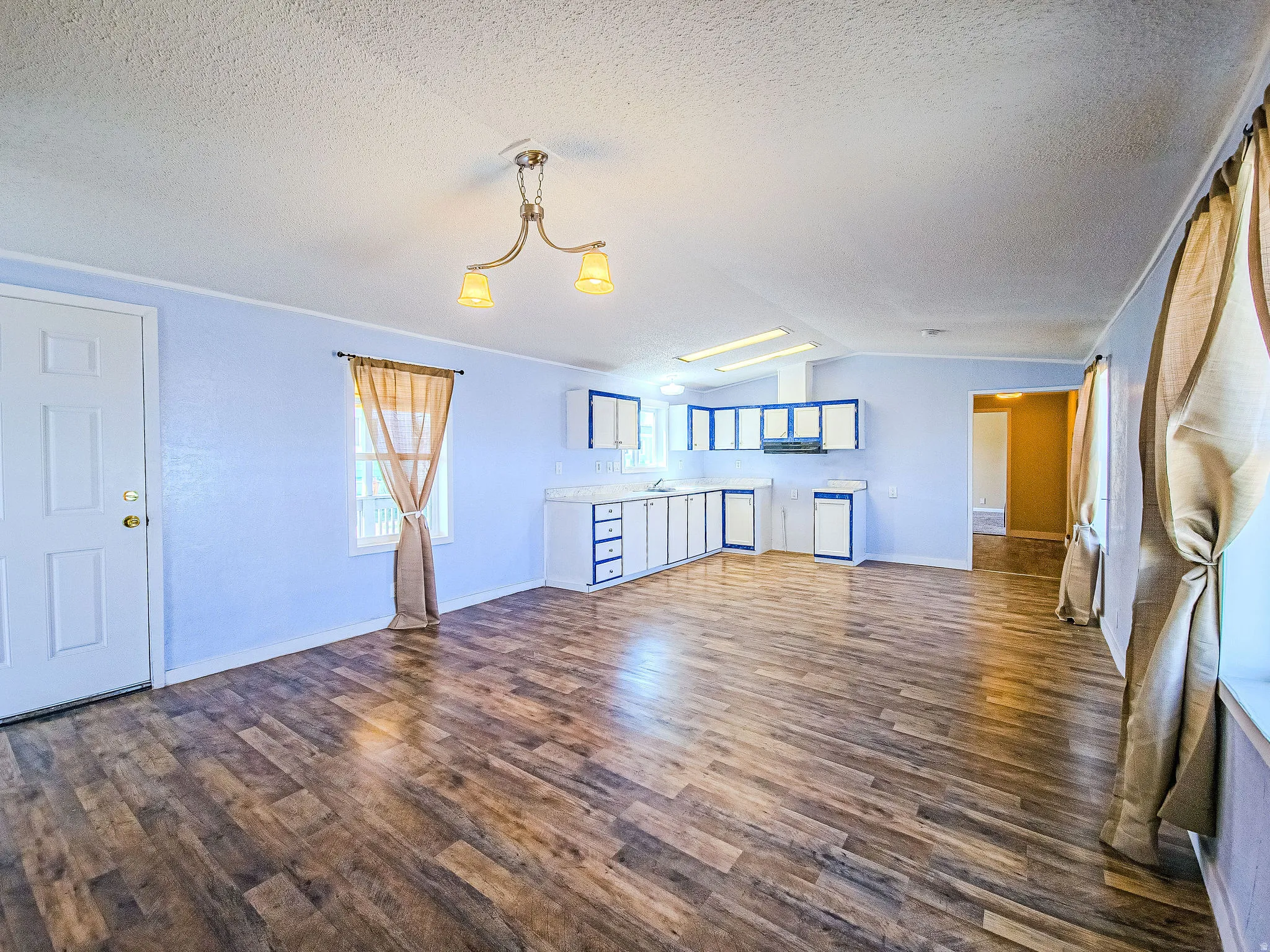 Unfurnished living room with dark wood-type flooring and baseboards