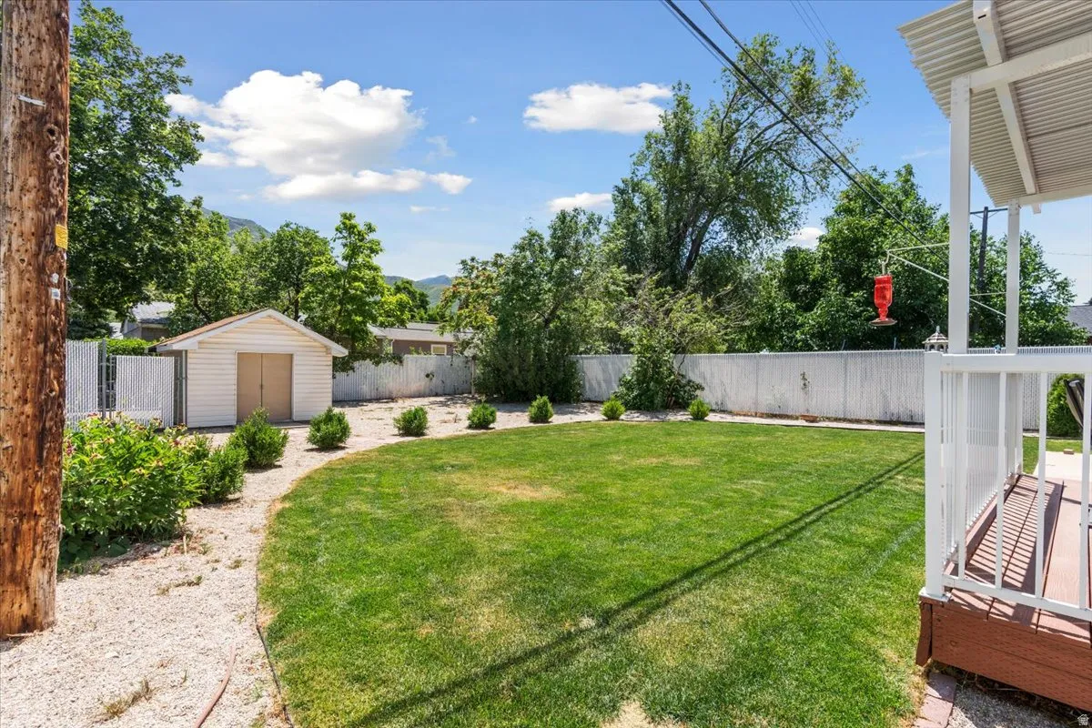 Fenced backyard featuring a storage shed