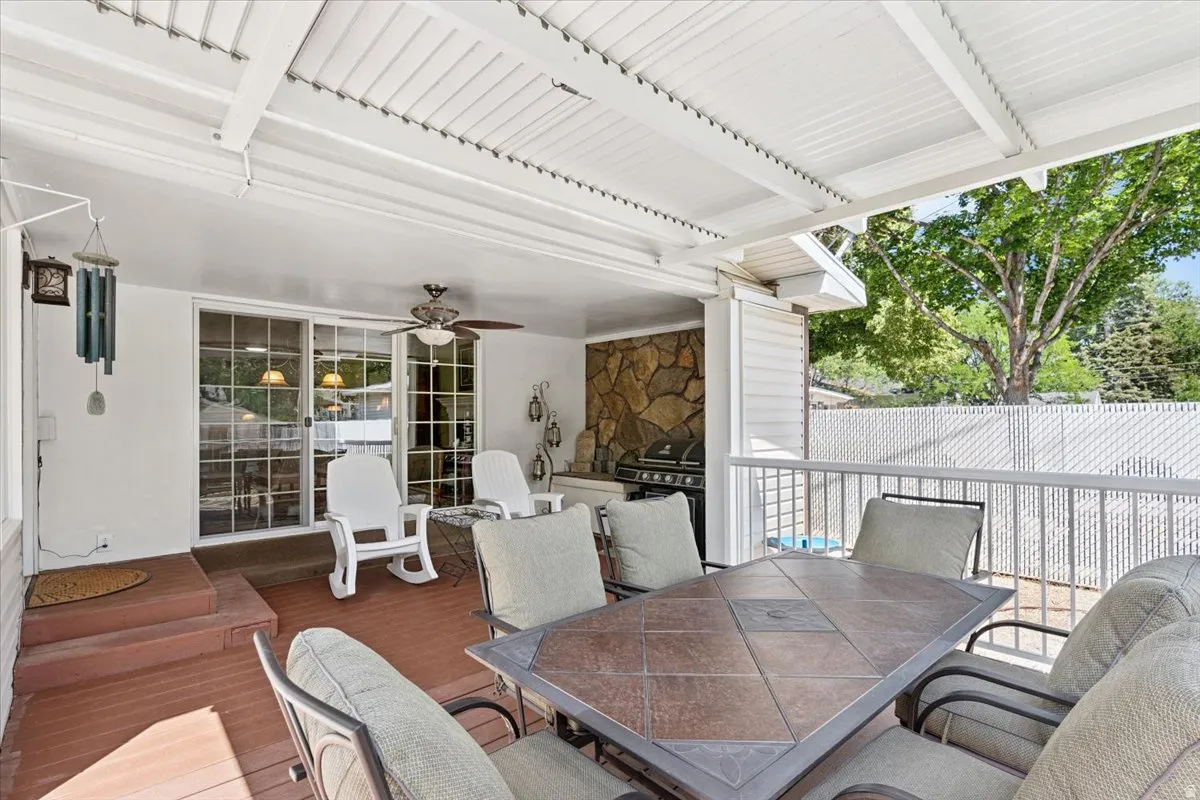 View of patio featuring outdoor dining area, a ceiling fan, a deck, and area for grilling