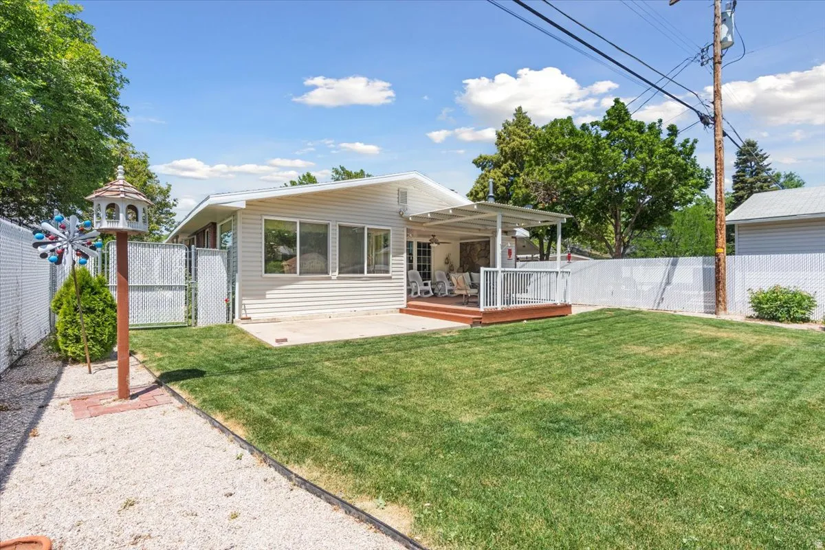 Back of house with a gate, a fenced backyard, a deck, and a patio area