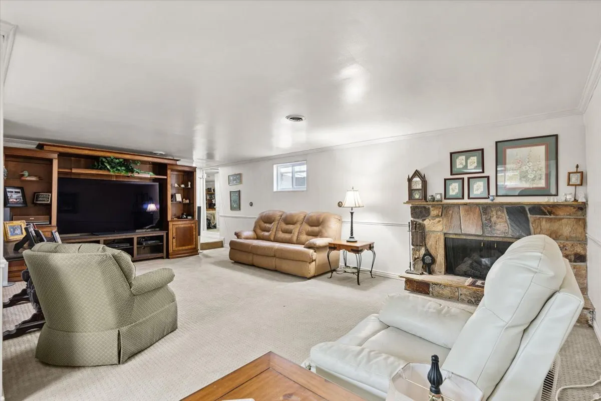 Family room withdrawn molding, carpet, and a stone fireplace