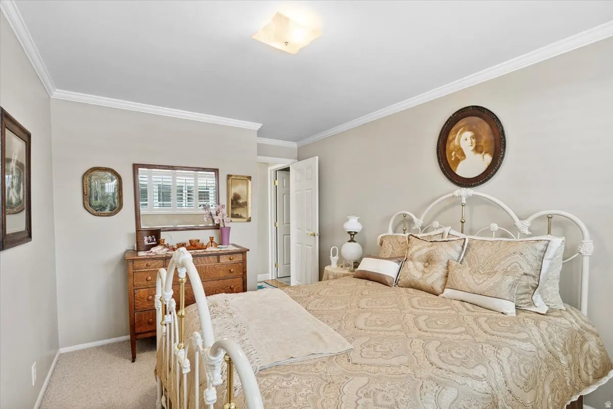 Bedroom with light carpet and crown molding