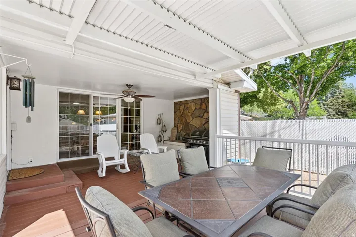View of patio featuring outdoor dining area, a ceiling fan, a deck, and area for grilling