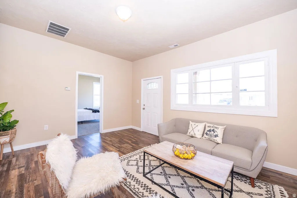 Living area featuring baseboards and dark wood-type flooring