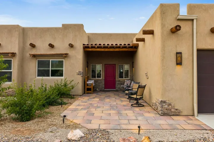 Property entrance with a patio, stucco siding, and a garage