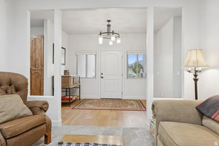 Entrance foyer with light wood-type flooring and suspended lighting