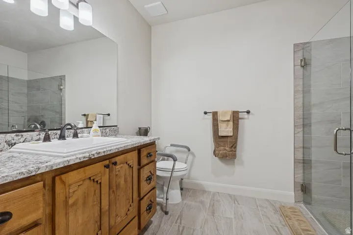 Full bath with a shower stall and vanity