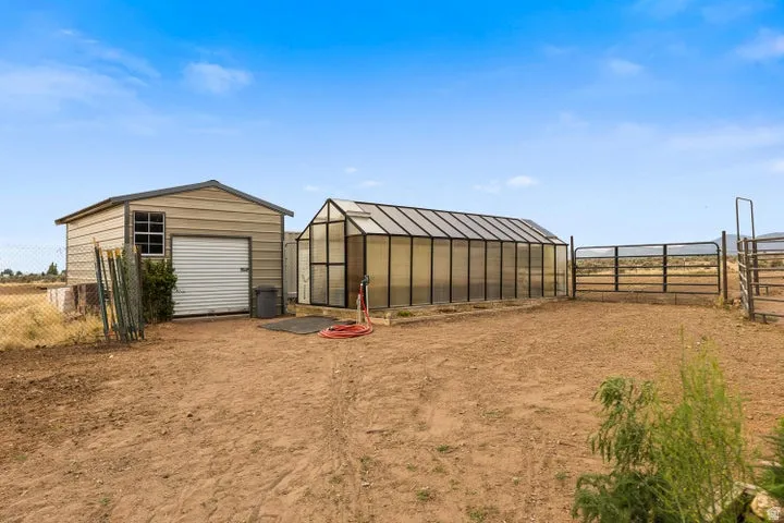 View of yard with an outbuilding and a greenhouse
