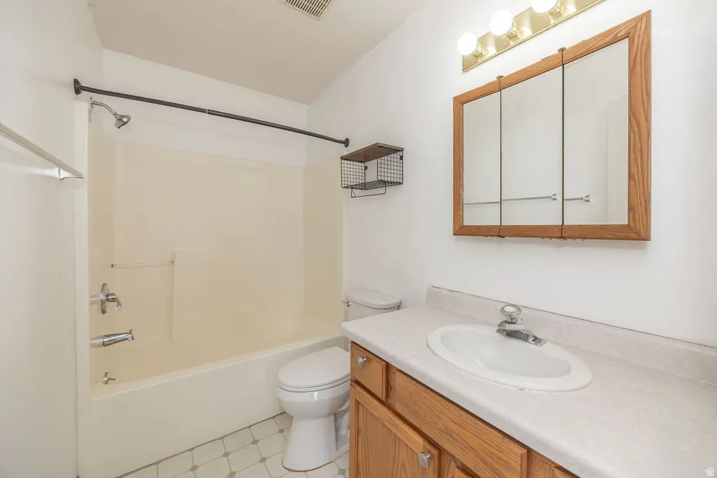 Bathroom featuring vanity, bathing tub / shower combination, and light flooring