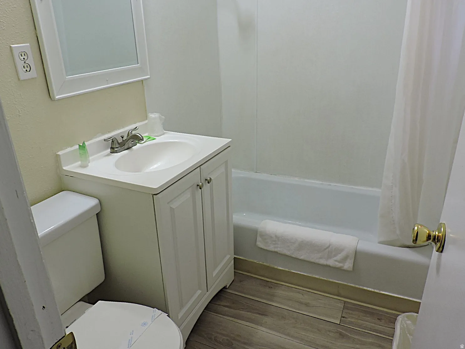 Bathroom with vanity, light wood-style floors, and shower / tub combo
