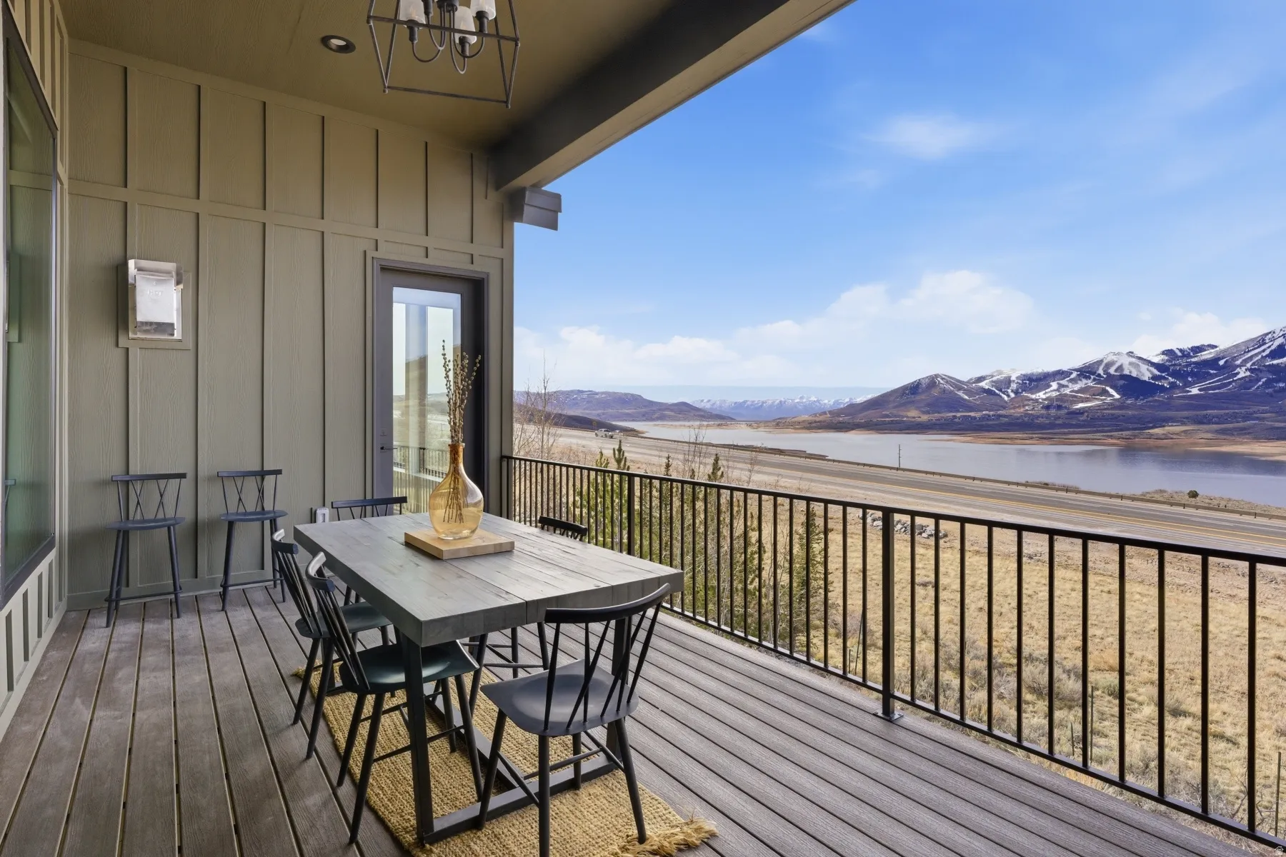 Deck with outdoor dining area and a water and mountain view