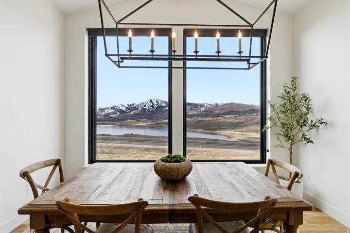 Dining room with wood finished floors, a water and mountain view, and plenty of natural light