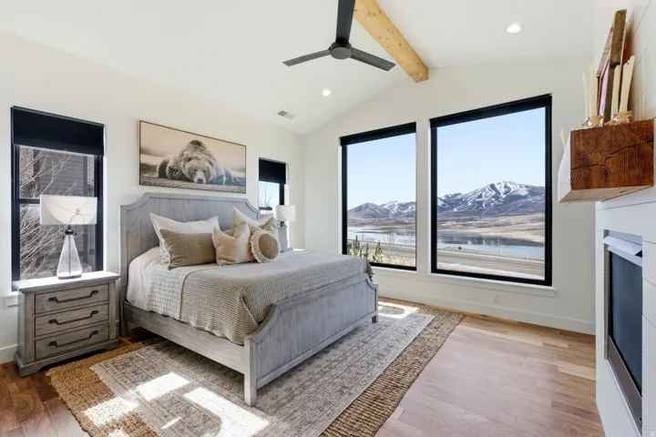 Bedroom with a ceiling fan, recessed lighting, light wood-type flooring, beamed ceiling, and a water and mountain view