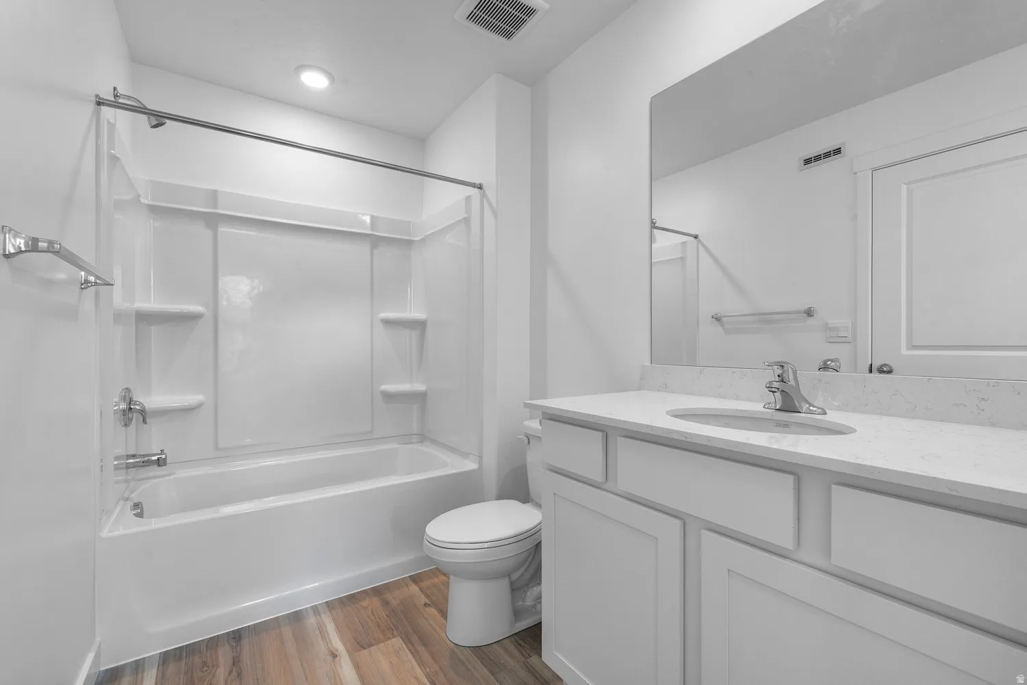 Full bathroom featuring dark wood-style floors, vanity, and shower / washtub combination