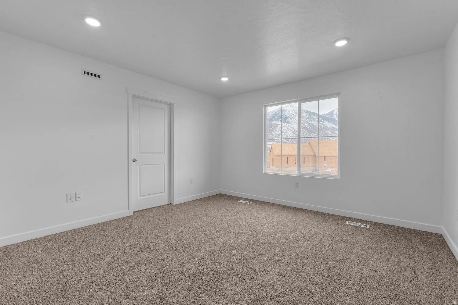 Carpeted spare room featuring baseboards and recessed lighting