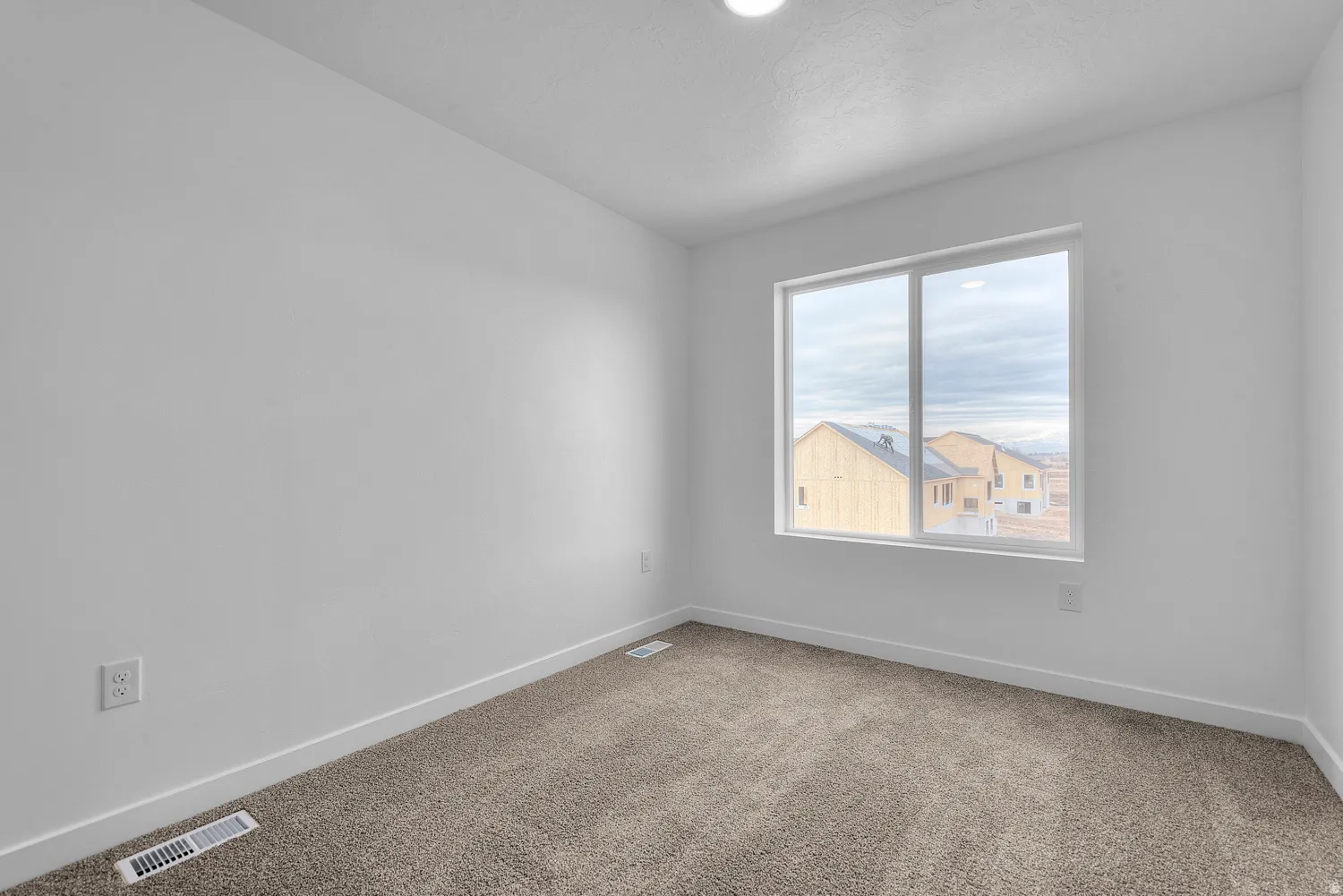 Carpeted empty room featuring baseboards